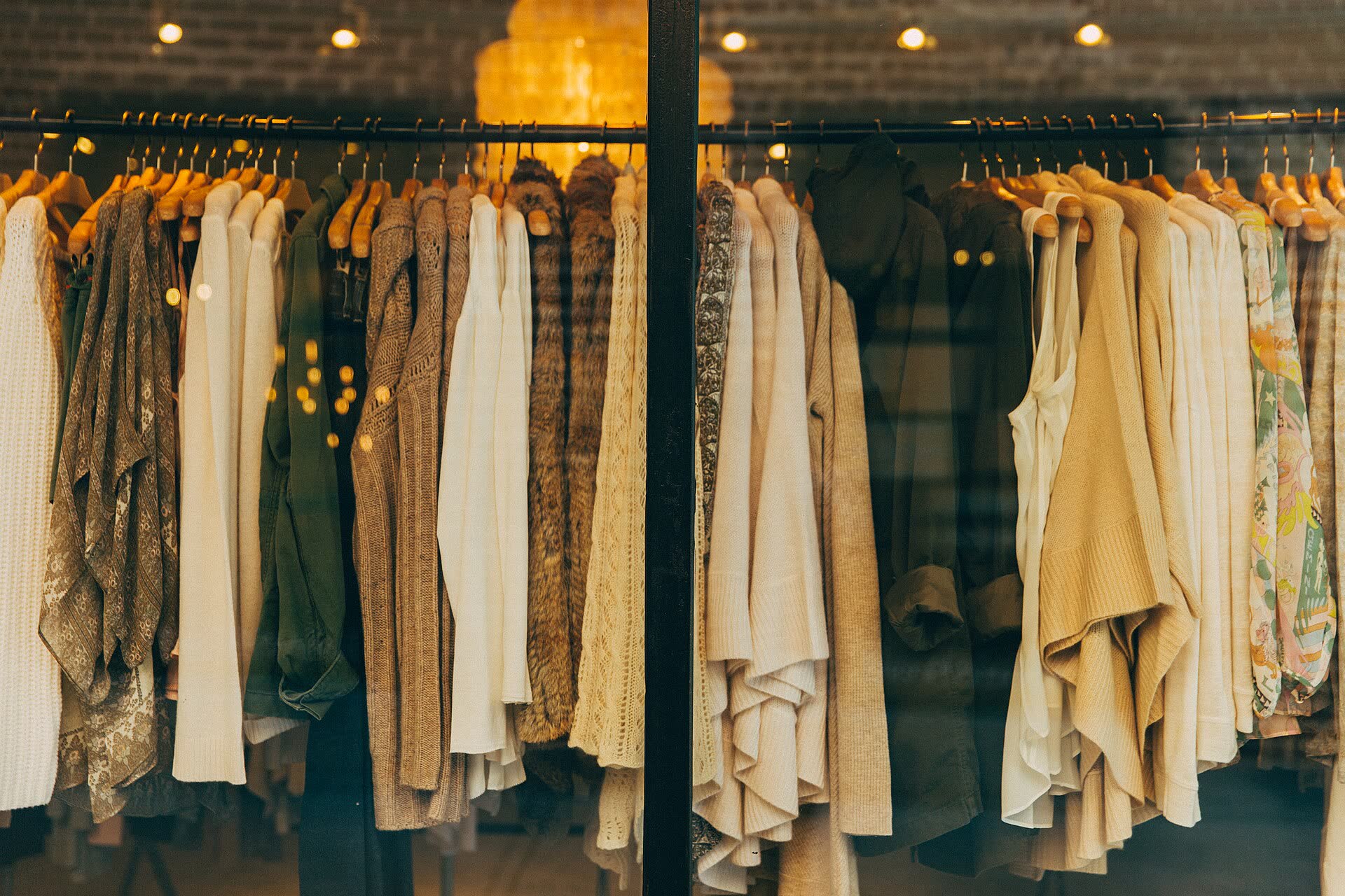L’interno di una boutique con una commessa che sistema la merce sugli scaffali